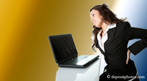 a person Williamson bending over a computer holding her back due to pain